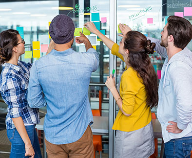 Business people brainstorming digital marketing strategy with sticky notes.